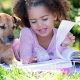 Photo of a girl reading with a dog