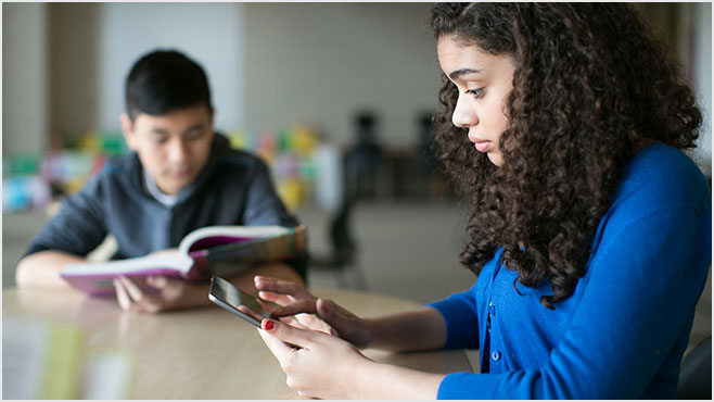 Photo of a girl and a boy reading